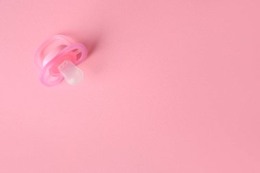 New baby pacifier on pink background, top view. Space for text
