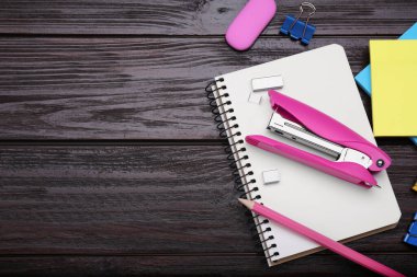 Flat lay composition with new stapler on wooden table, space for text