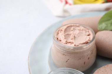 Delicious liver sausages and paste on white table, closeup. Space for text