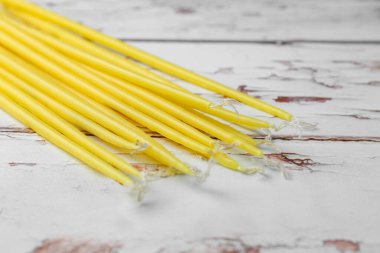 Church candles on white wooden table, closeup