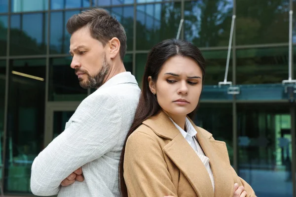 Upset arguing couple near building outdoors. Relationship problems
