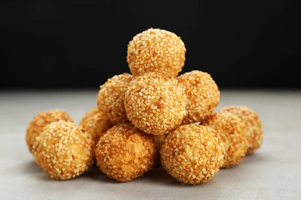 Many delicious sesame balls on textured table