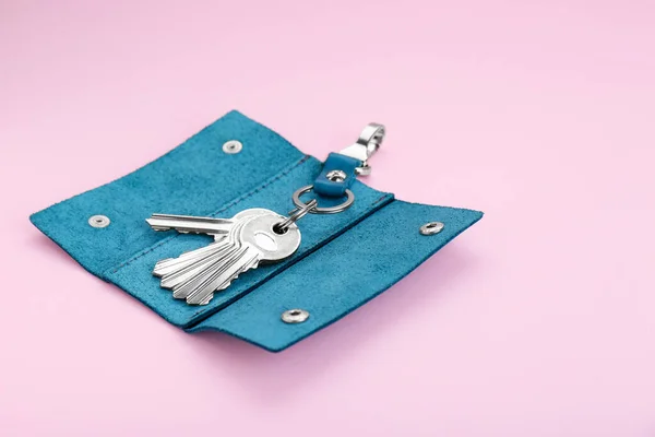 Stylish leather holder with keys on pink background