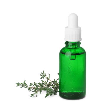 Bottle of thyme essential oil and fresh plant isolated on white
