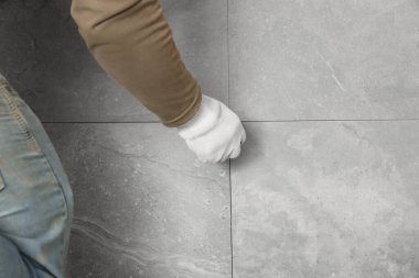 Worker installing new wall tile, closeup. Prepared for renovation
