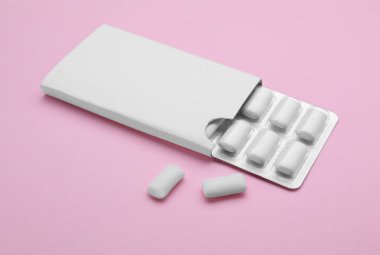 Blister with chewing gums on pink background