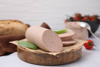 Delicious liver sausage on light grey table, closeup