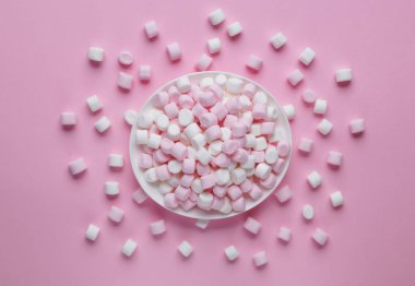 Plate with delicious marshmallows on pink background, flat lay