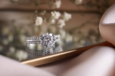 Elegant jewelry. Stylish presentation of luxury ring on mirror, closeup