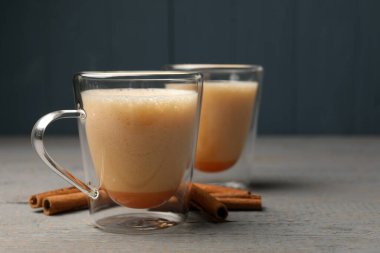 Delicious eggnog with cinnamon on grey wooden table