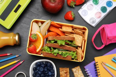Flat lay composition with lunch box, tasty healthy food and school stationery on grey table