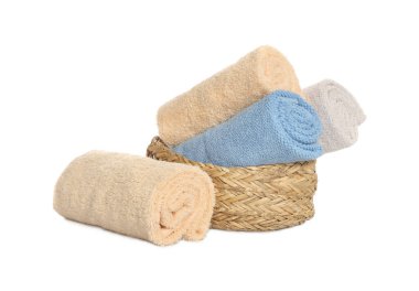 Wicker basket and rolled bath towels on white background