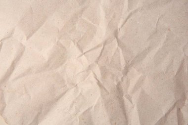 Sheet of crumpled light brown paper as background, top view