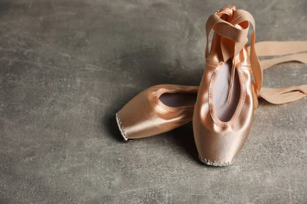 Ballet shoes. Elegant pointes on grey textured background, space for text