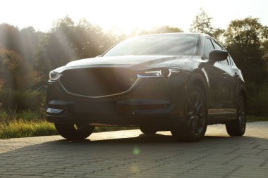 Siyah modern araba asfalt yolda gün batımında