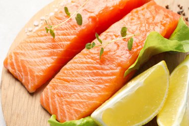 Taze çiğ somon ve ahşap tahtada terbiye edilecek malzemeler, yakın plan.