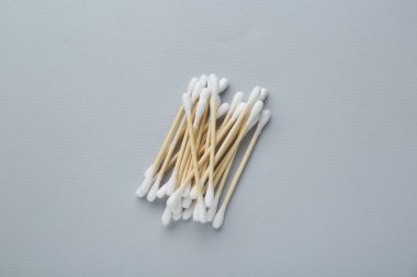 Many wooden cotton buds on light grey background, flat lay