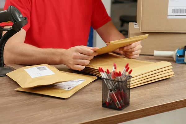 Postkantoor Medewerker Met Zelfklevende Papieren Zakken Aan Balie Binnen Close — Stockfoto