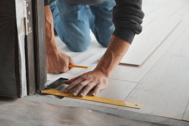 İşçi odaya yeni kaplama döşemeler kuruyor, kapatıyor