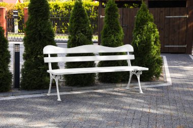 Stylish white wooden bench in garden on sunny day