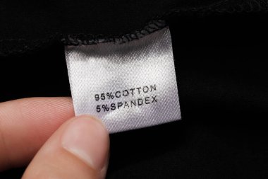 Siyah elbisenin üzerinde kıyafet etiketi olan kadın, yakın plan.