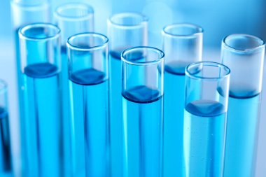 Laboratuvarda açık mavi sıvıyla test tüpleri, yakın plan.