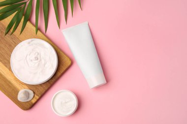 Düz kompozisyon ve pembe arka planda farklı kozmetik ürünler. Metin için boşluk