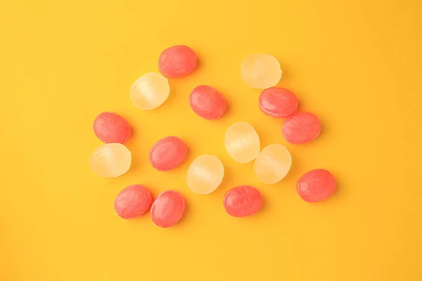 Many different colorful cough drops on orange background, flat lay