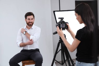 Professional photographer working with handsome model in modern photo studio