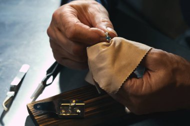 Professional jeweler working with ring at table, closeup