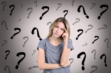 Amnesia concept. Woman trying to remember something. Question marks on color background symbolizing memory loss