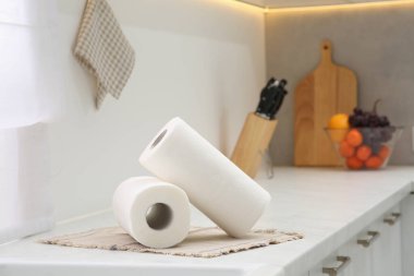 Rolls of paper towels on white countertop in kitchen. Space for text