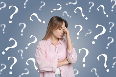 Amnesia concept. Woman surrounded by question marks trying to remember something on color background