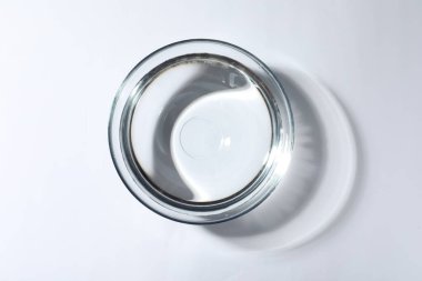 Beyaz arka planda su olan cam kase, üst manzara.