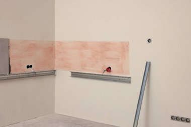 Kapalı alanda duvarda yapıştırıcı ve fayans var.