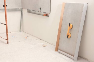 Duvarın yanındaki fayansa sarı emme plakası takılı.