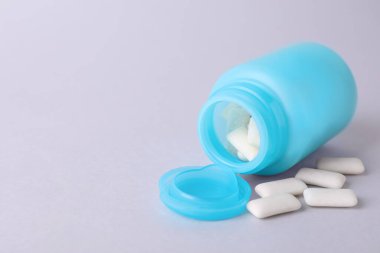 Açık gri arkaplanda sakız çiğneyen kavanoz