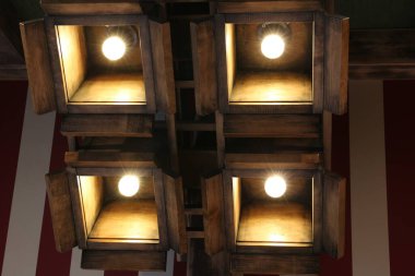 Stylish pendant lamps on ceiling in hotel room, low angle view