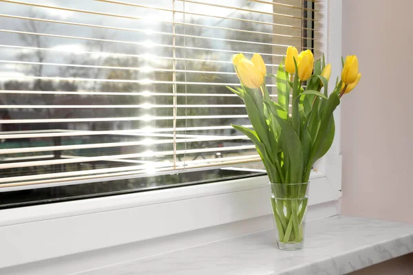 Wonderful tulips on window sill indoors, space for text. Spring atmosphere