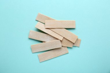 Many sticks of tasty chewing gum on light blue background, flat lay