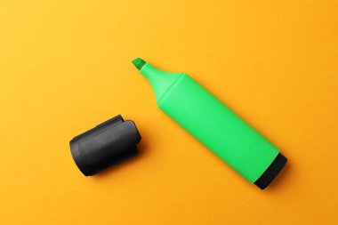 Bright marker on orange background, flat lay
