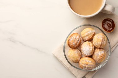 Homemade walnut shaped cookies with boiled condensed milk and coffee on white marble table, flat lay. Space for text