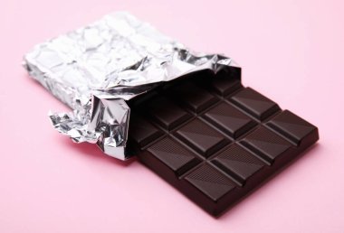 One tasty chocolate bar on pink background