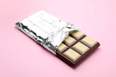 One tasty chocolate bar on pink background