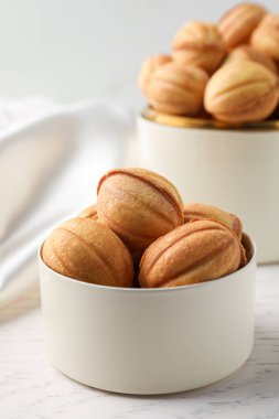 Delicious nut shaped cookies on white wooden table
