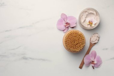 Flat lay composition with spa products and flowers on white marble table. Space for text