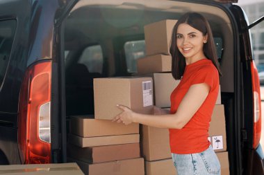 Kurye teslimat minibüsünden paket alıyor.