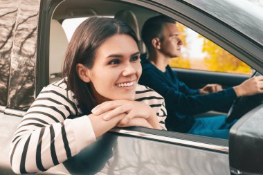 Mutlu genç çift arabayla seyahat ediyor.