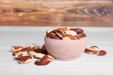 Many tasty Brazil nuts on white wooden table