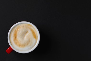 Cup with aromatic cappuccino on black background, top view. Space for text